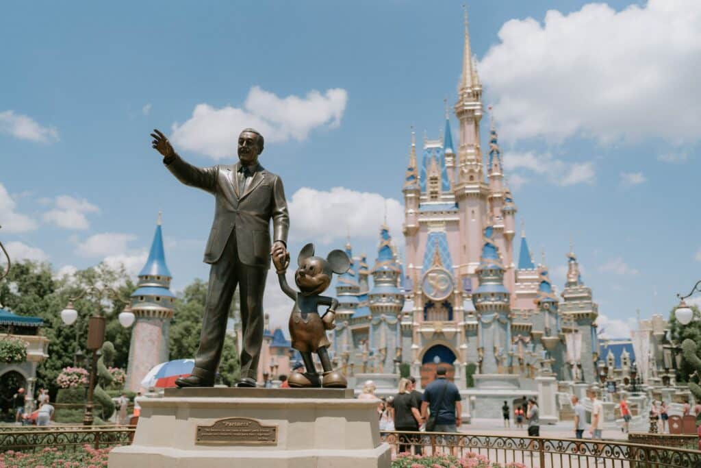 Statue of Mickey and Walt Disney standing in front of Cinderella's Castle at Magic Kingdom in Walt Disney World