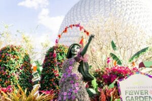 a statue of a woman in a dress with flowers and a large dome